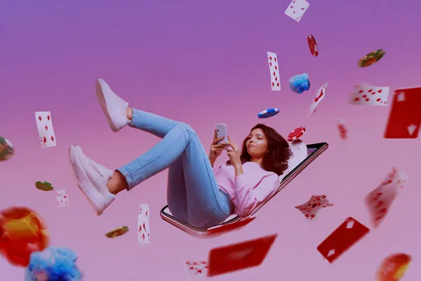 A young woman relaxing with her phone while dynamic casino elements float around her, illustrating the smooth mobile experience offered by the OKTKBD app.