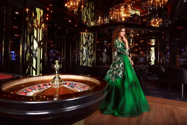 A professional dealer in a tuxedo greeting players at the roulette table, symbolizing the authentic live casino feel at OKTKBD.