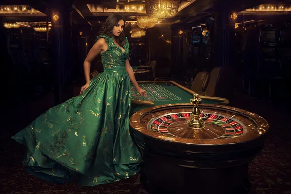 A man celebrating a winning moment on his laptop while gaming symbols float around him, capturing the excitement of OKTKBD games.